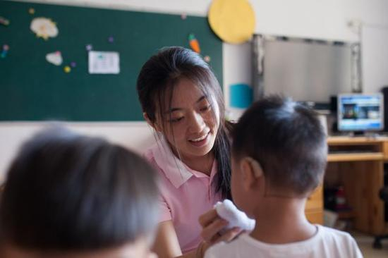 彭晓雯为刚吃过午饭的小朋友擦嘴（9月7日摄）。