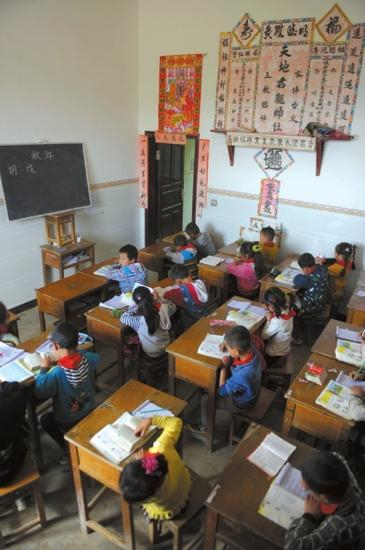 小学生正在民居中上课，教室里光线并不是很好。