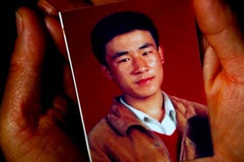 ▲去年10月31日，呼格吉勒图的母亲手捧儿子的照片。新京报记者 郭铁流 摄