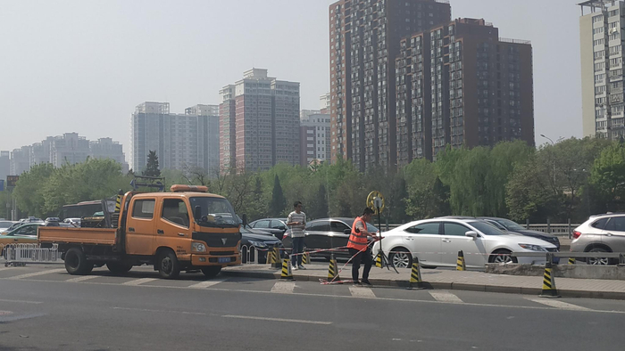  涉事车辆已被拖走，现场有多名市政道路养护工作人员正在作业。新京报记者 刘名洋 摄
