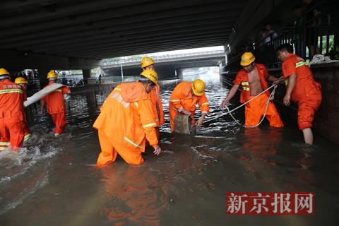 回龙观育知东路城铁桥下抢险救援人员在安装排水泵。新京报记者 王贵彬 摄