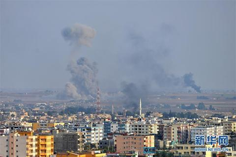  这是10月11日在土耳其边境的杰伊兰珀纳尔附近拍摄的遭到土军炮击的叙利亚拉斯艾因市。 （图源：新华社）