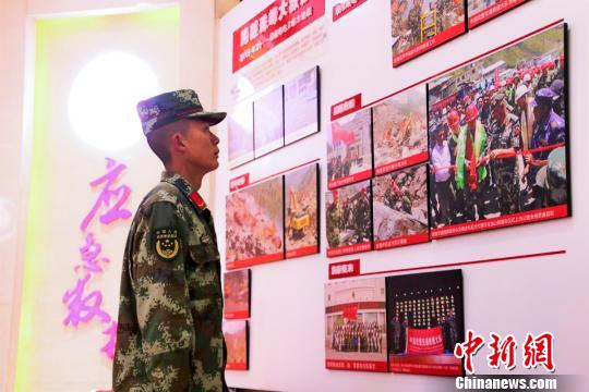 图为陈伟走进支队史馆了解支队历史。武警某部交通三支队供图