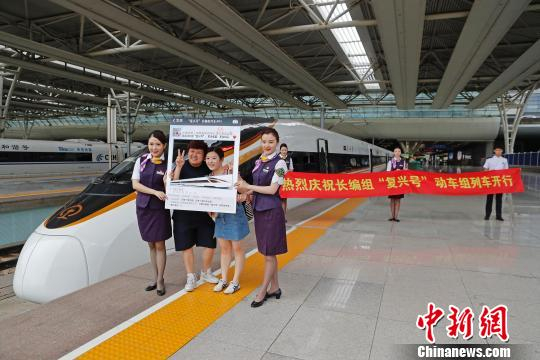  旅客在长编组“复兴号”动车组车头部位合影留念。　殷立勤　摄