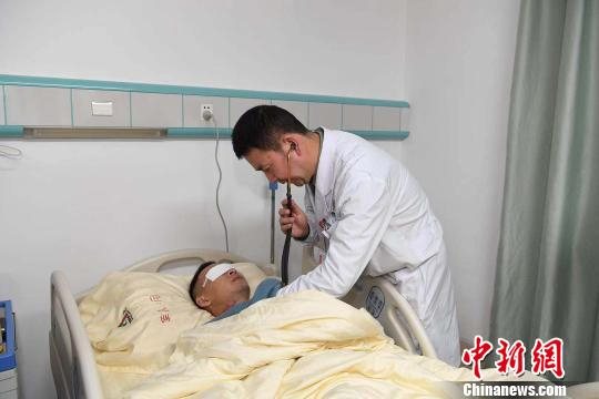 图为医生为杜富国检查。　肖瑶 摄