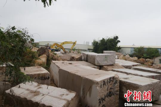 翁梅斋墓墓道通往墓丘处，堆放着当地石材企业的石料、作业车辆。　陈启任 摄