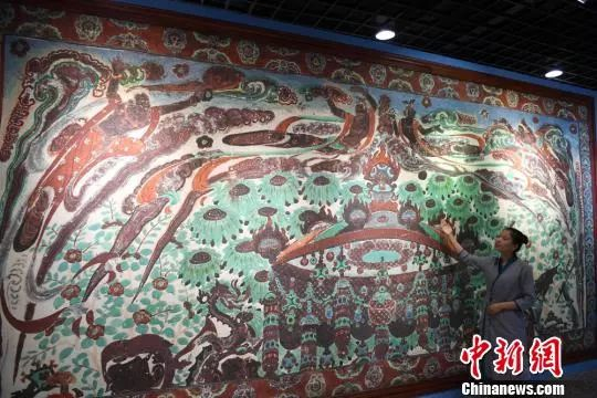 　　资料图：2018年8月6日，通过数字化采集后打印展出的大幅高保真莫高窟复制壁画320窟“散花飞天”亮相敦煌。　杨艳敏　摄