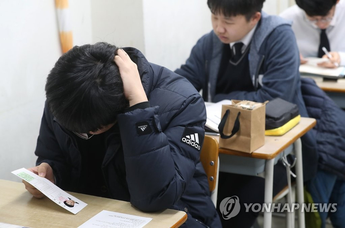 13日，在首尔龙山高中，学生查看准考证。 （韩联社）