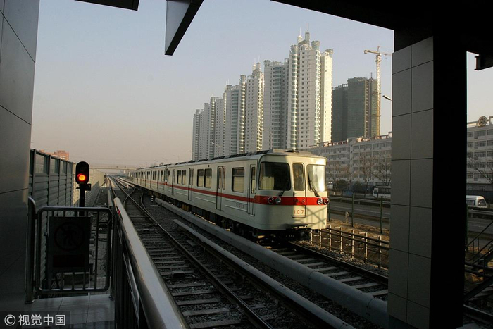　2003年12月27日，北京地铁八通线正式全线通车运营。列车驶过珠江绿洲楼群，八通线的开通带动北京东部沿线楼盘升温。图片来源：视觉中国
