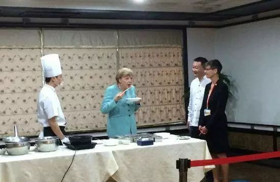 △默克尔用筷子吃宫保鸡丁