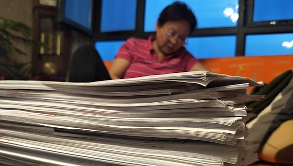 厚厚的病例和诉讼材料堆满了桌子。图片来源：刘成伟 摄