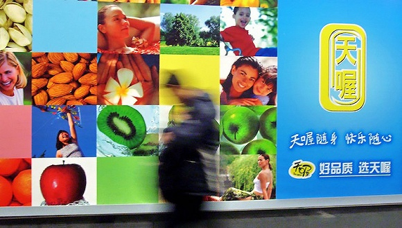 上海，行人从一则天喔食品广告前走过。图片来源：视觉中国