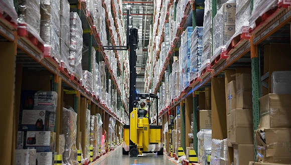 &nbsp;印度班加罗尔的一名工人从亚马逊的存储架上卸货。图片来源：视觉中国