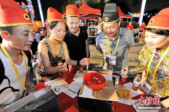 资料图：海峡两岸民众在厦门戴“状元帽”博“状元”，体验传统文化。中新社发 王东明 摄