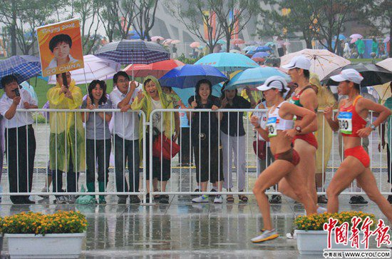 2008年8月21日，北京奥林匹克公园中心区，人们冒雨观看奥运会女子10公里竞走比赛。中国青年报·中青在线记者&nbsp;陈剑/摄