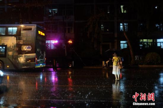 资料图：民众冒雨出行。中新网记者 李骏 摄