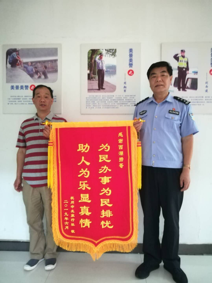 周翔军（右）帮助游客打捞手机，游客送来锦旗表示感谢。 &nbsp;受访者供图