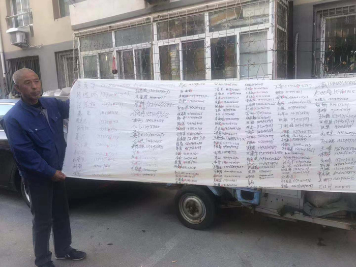 小琪的爷爷手持支持他们的社区住户的签名。新京报记者 王昱倩 摄