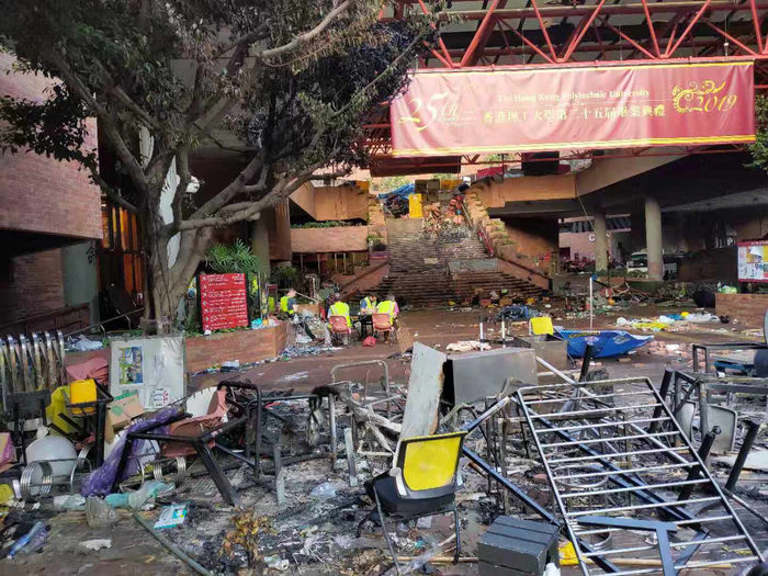 学校门口堆放的桌椅、砖头、雨伞等杂物。 新京报特派香港报道组 摄