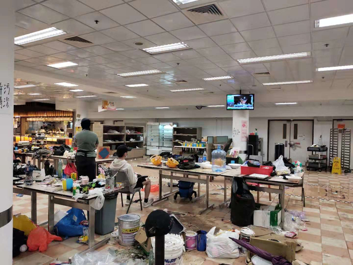 食堂内有人观看警方记者会直播。新京报特派香港报道组 摄