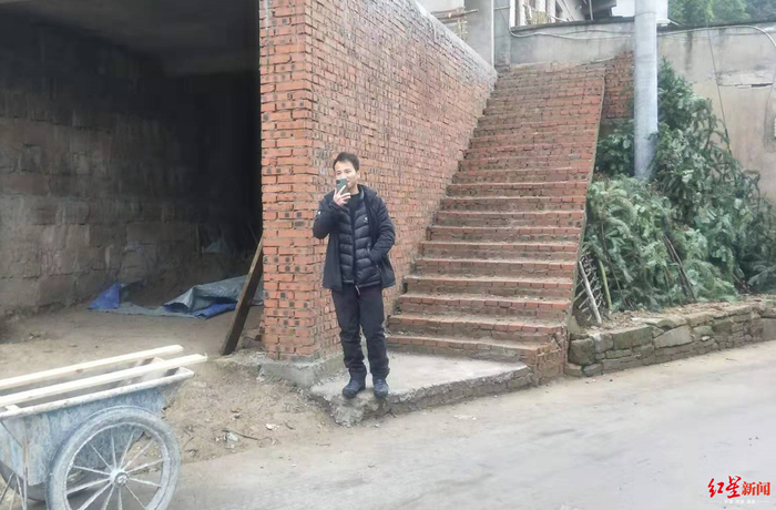 王相军站在老家尚未完工的新房前。