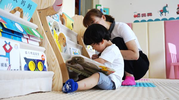 宁陕县城南养育中心，一位年轻的母亲正在陪孩子读绘本
