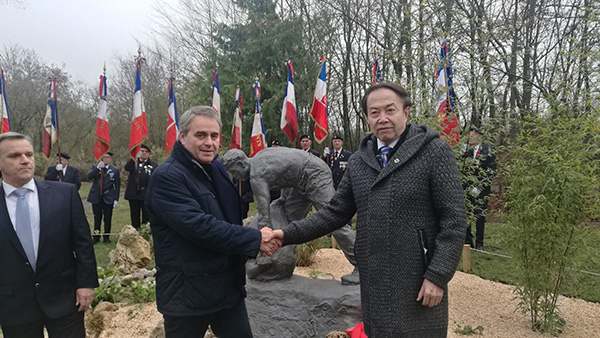 　雕塑家袁熙坤在雕塑前与上法大区主席握手。