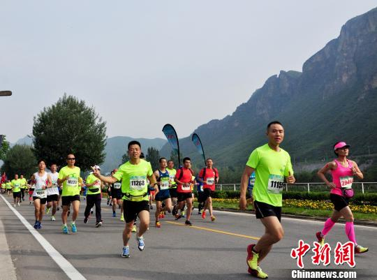 选手们沿着被群山和花海簇拥的赛道前行。　赵庆斌 摄