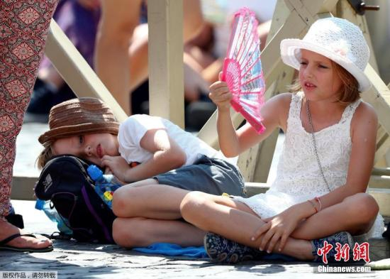 小朋友被晒“蔫”，高温出行一脸愁容。