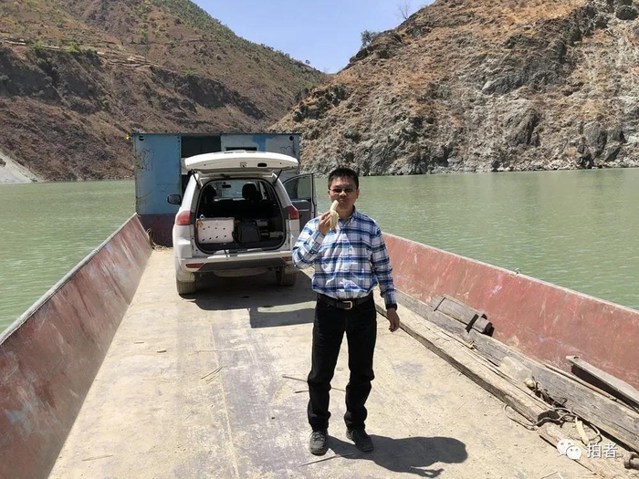  △&nbsp;2019年4月7日，四川凉山州，木里森林火灾后，新京报记者吴江在前往拍摄点的摆渡船上吃香蕉补充体力。摄影/麦圈