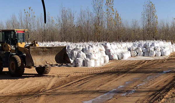 　污染场地中工人对污染物挖掘清理后进行装袋。澎湃新闻记者 陈雷柱 图