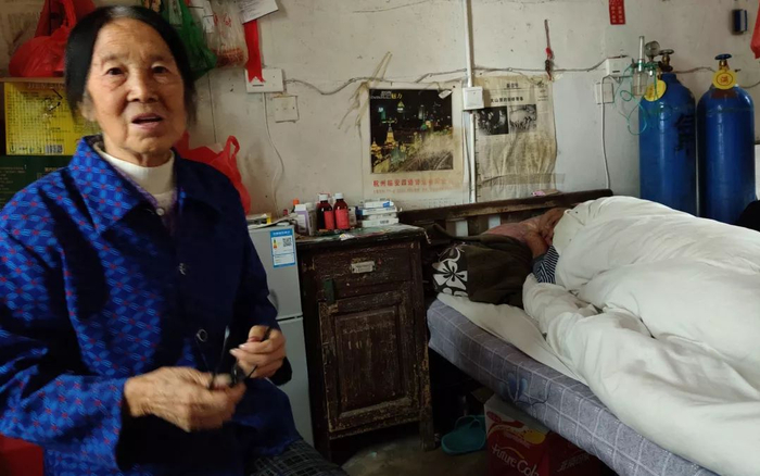 ▲李四妹在病房中，经常卧床不起的是她的丈夫涂关新。新京报记者 张一川 摄