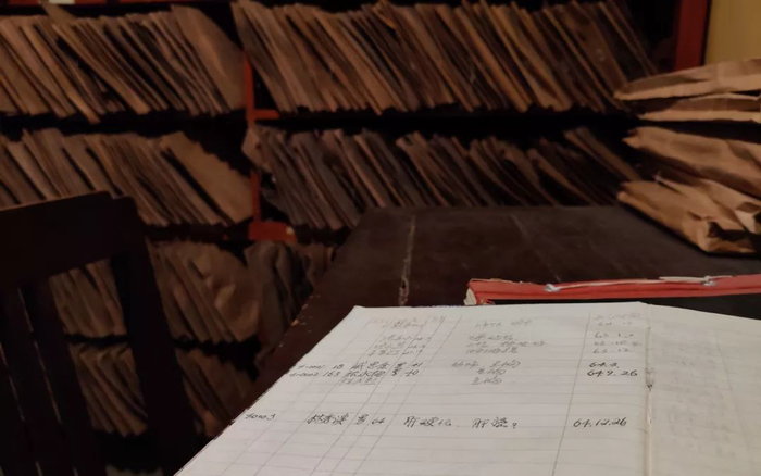 　　▲副院长李金川会在这个笔记本上记下在医院去世的病人和死因，后方的铁架上摆满了“死亡病历”。新京报记者 张一川 摄