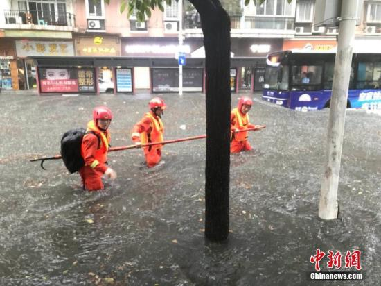 消防官兵深入内涝区寻找被困人员。罗磊 摄