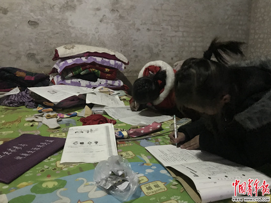 1月4日，张欢张圆姐妹正趴在床上写作业。中国青年报·中青在线记者&nbsp;孙庆玲/摄