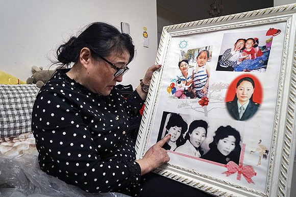 李桂花把逝去的亲人都放到了同一张照片中，想念时就看看他们。摄影：吕萌