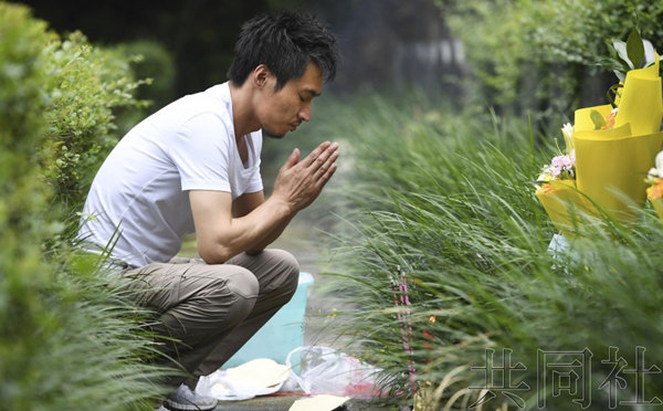 市川泰之为恋人彭飞扫墓。（图片来源：日本共同社）