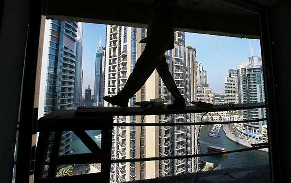  阿联酋迪拜，一名工人走在建筑工地的脚手架上。东方IC 资料图