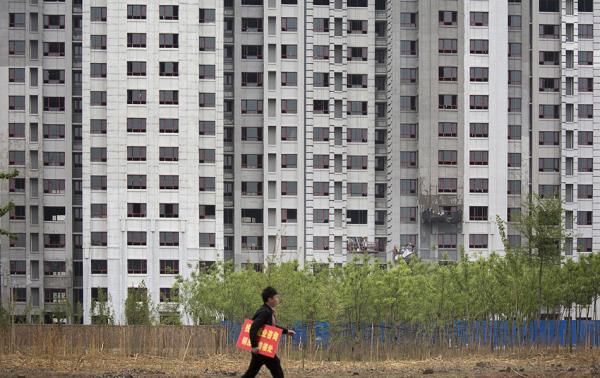 河北廊坊，售楼人员走过一处楼盘。 视觉中国 图