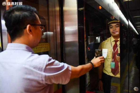  （场景还原）萧先生（左）用手机向地铁司机陈佳洪（右）寻求帮助。