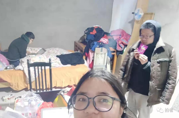  △&nbsp;2019年3月24日，江苏盐城，新京报记者们住在距离响水爆炸核心区500米左右的民房。民房玻璃被震碎，四处漏风。康佳穿着村民的军大衣御寒，祖一飞窝在被子里写稿，没吃晚饭的向凯正在啃干脆面。摄影/新京报记者康佳