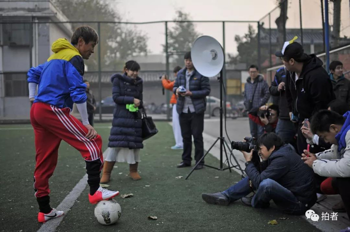  △&nbsp;2012年11月21日，北京东城区先农坛体育场，新京报记者郭延冰正在拍摄原中国足球队运动员。摄影/新京报记者陈杰