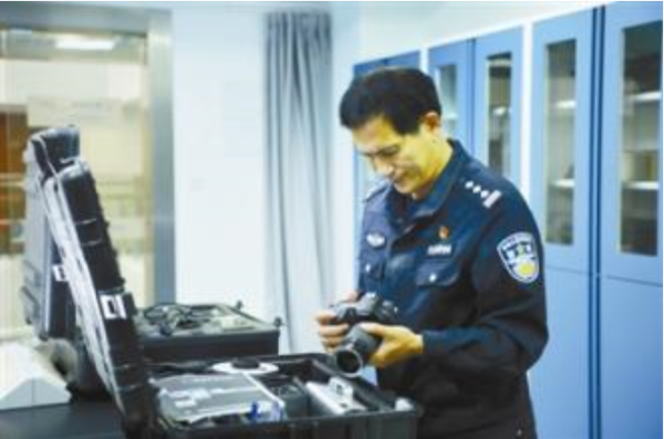 快退休的何海明，摆弄着他心爱的相机。