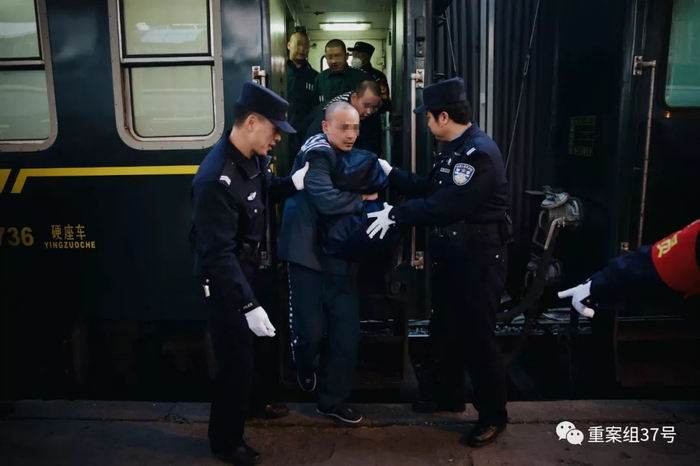▲列车抵达遣送地，服刑人员拿好随身行李，在民警的指挥下挨个走下列车。新京报记者 郑新洽 摄