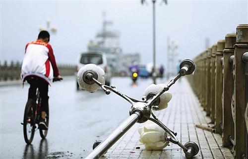  上图 9月17日，在广西柳州市融安县，市民骑车经过被台风吹倒的路灯。 谭凯兴摄（新华社发）