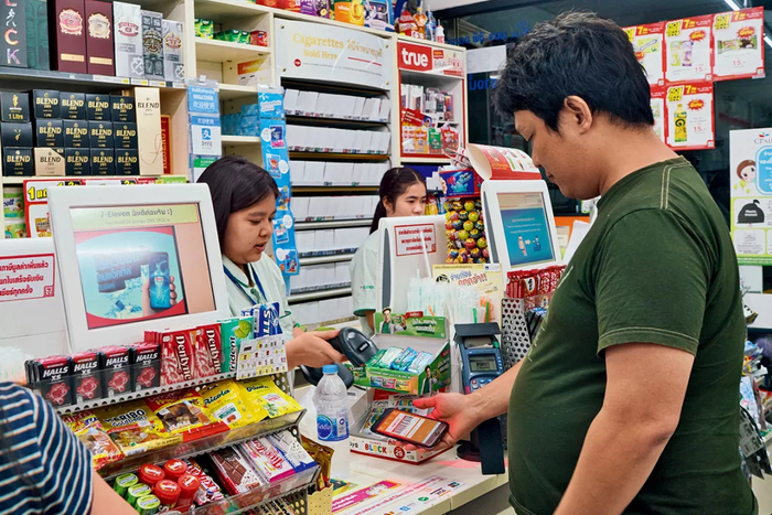 在7-EVELEn便利店里，泰国人用本地版“支付宝”TrueMoney扫一扫买东 西。