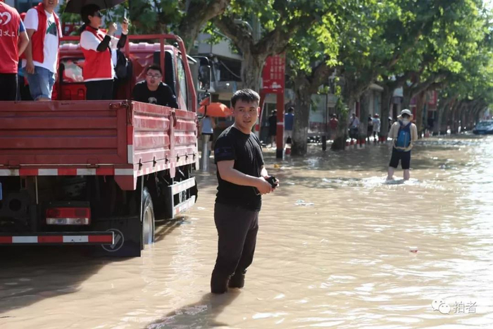 △&nbsp;2019年8月11日，浙江台州，当地受到了台风“利奇马”极大影响，新京报记者刘名洋站在汪洋中采访。摄影/新京报记者王嘉宁