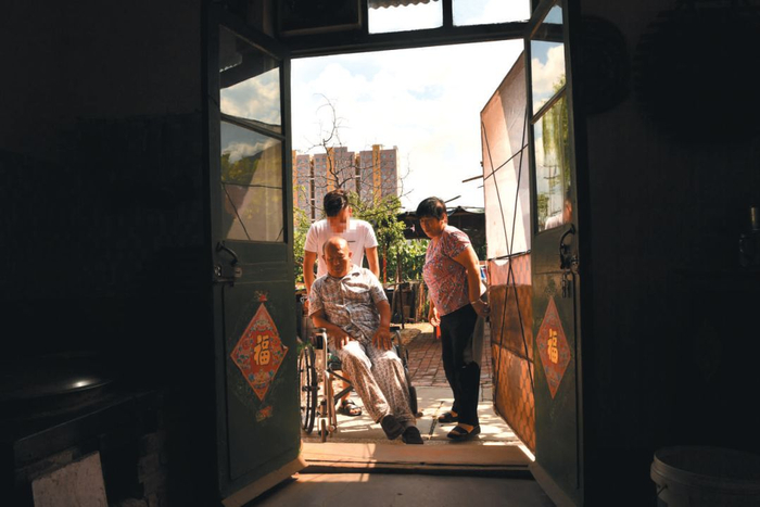 ▲8月17日，河北沧州市盐山县，刘小光用轮椅推着刘海兴。