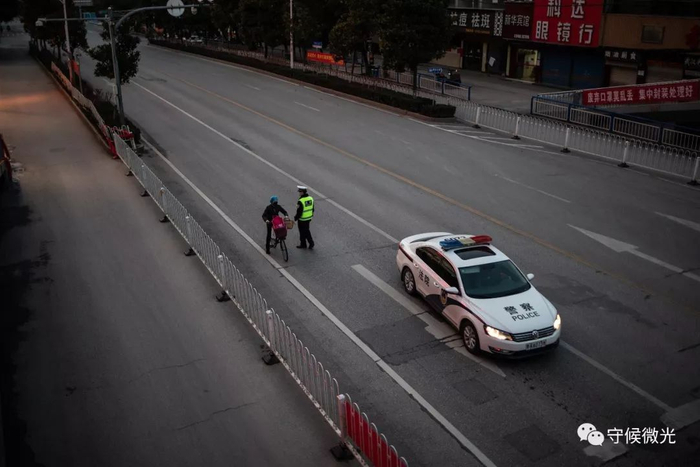 2月17日，湖北省孝感市槐荫大道，执勤警察拦住一名路人进行盘查。中青报·中青网记者 李隽辉/摄