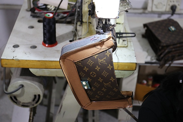 警方查处制假窝点时工人正在制假